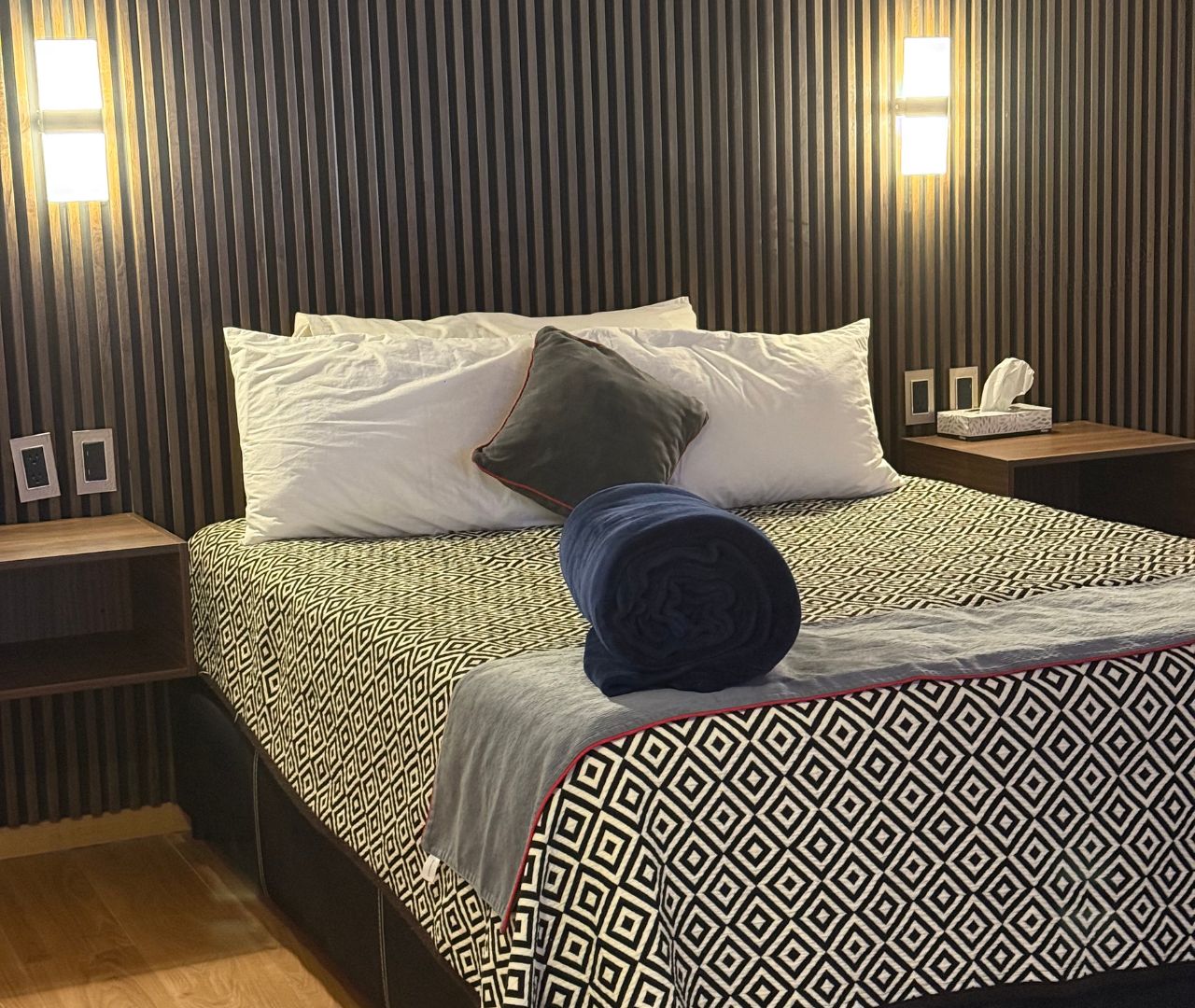 Cama Queen con muro de lambrín y luces de lectura